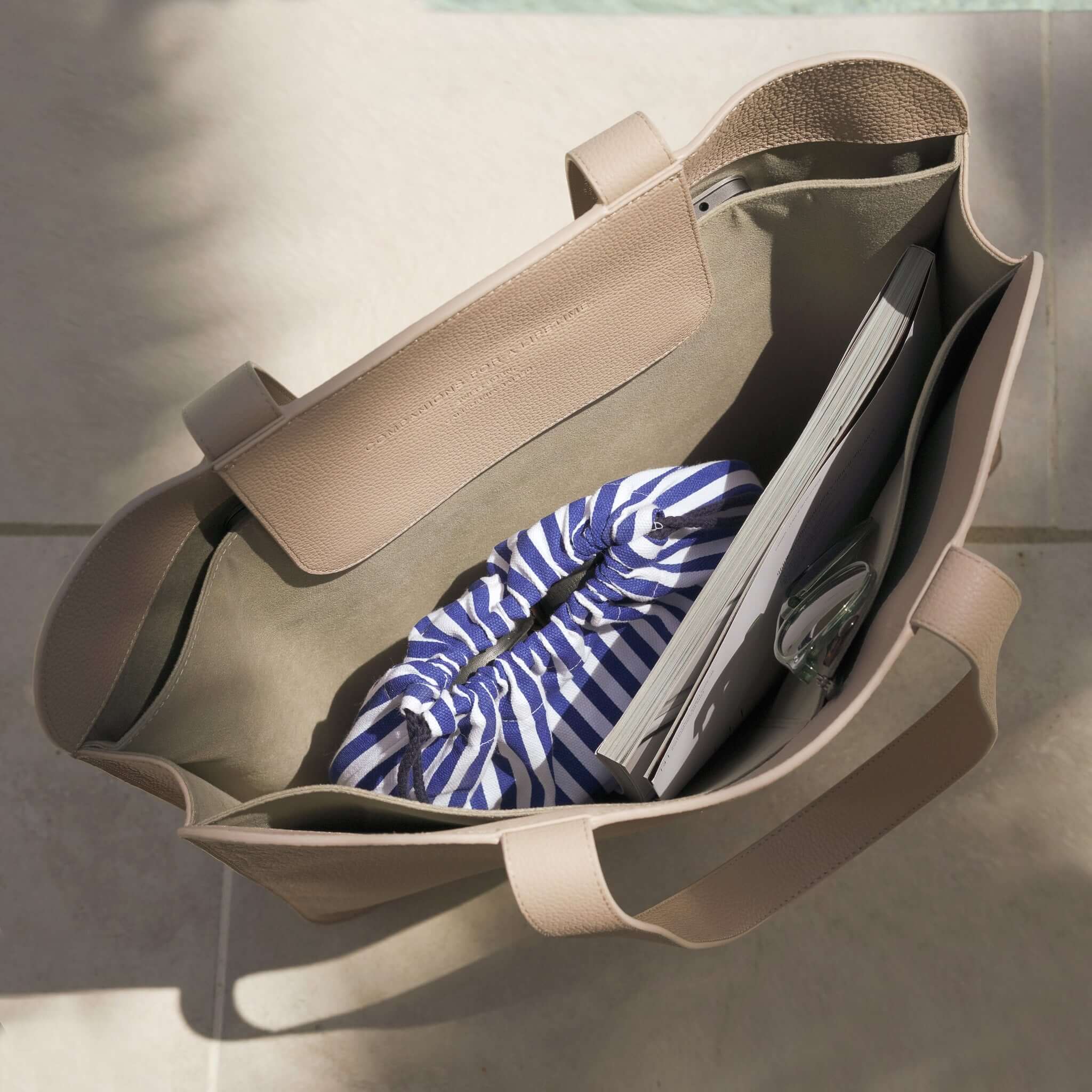 Open Sea Lavender Laptop Tote Bag showing spacious interior with a 17-inch laptop and striped pouch, handcrafted leather design.