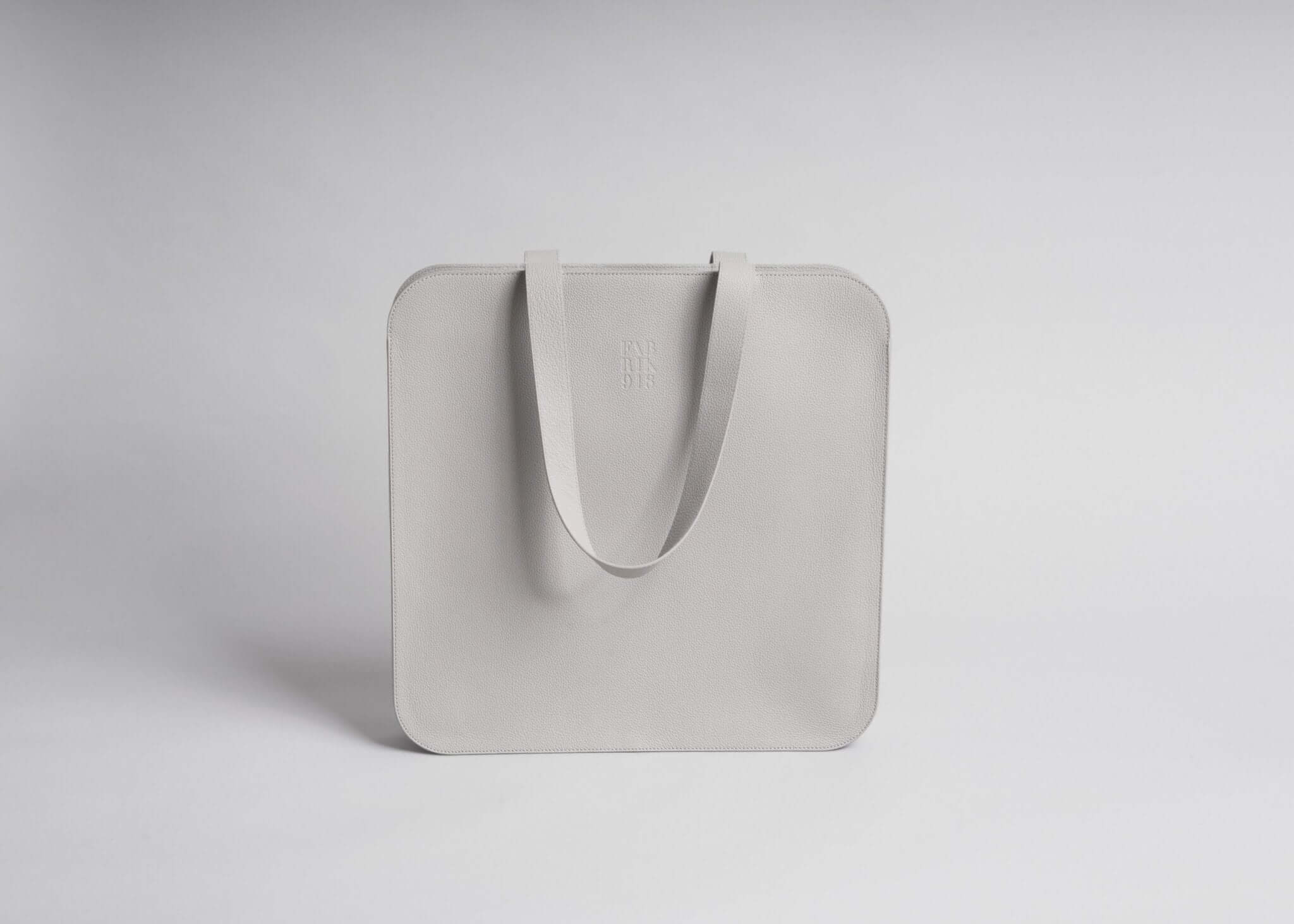 Minimalist square tote bag in light gray with a sleek design and sturdy handles, ideal for stylish and practical everyday use.